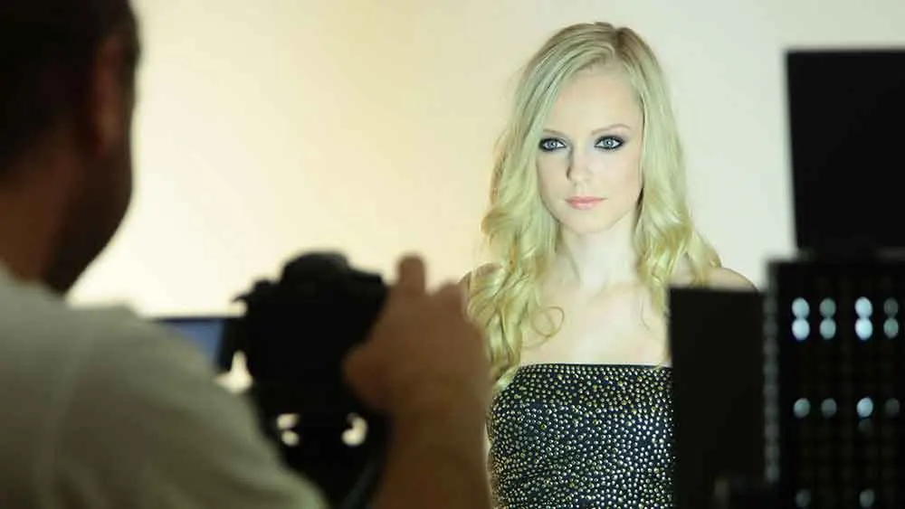 Beauty portrait being photographed against a warm studio backdrop