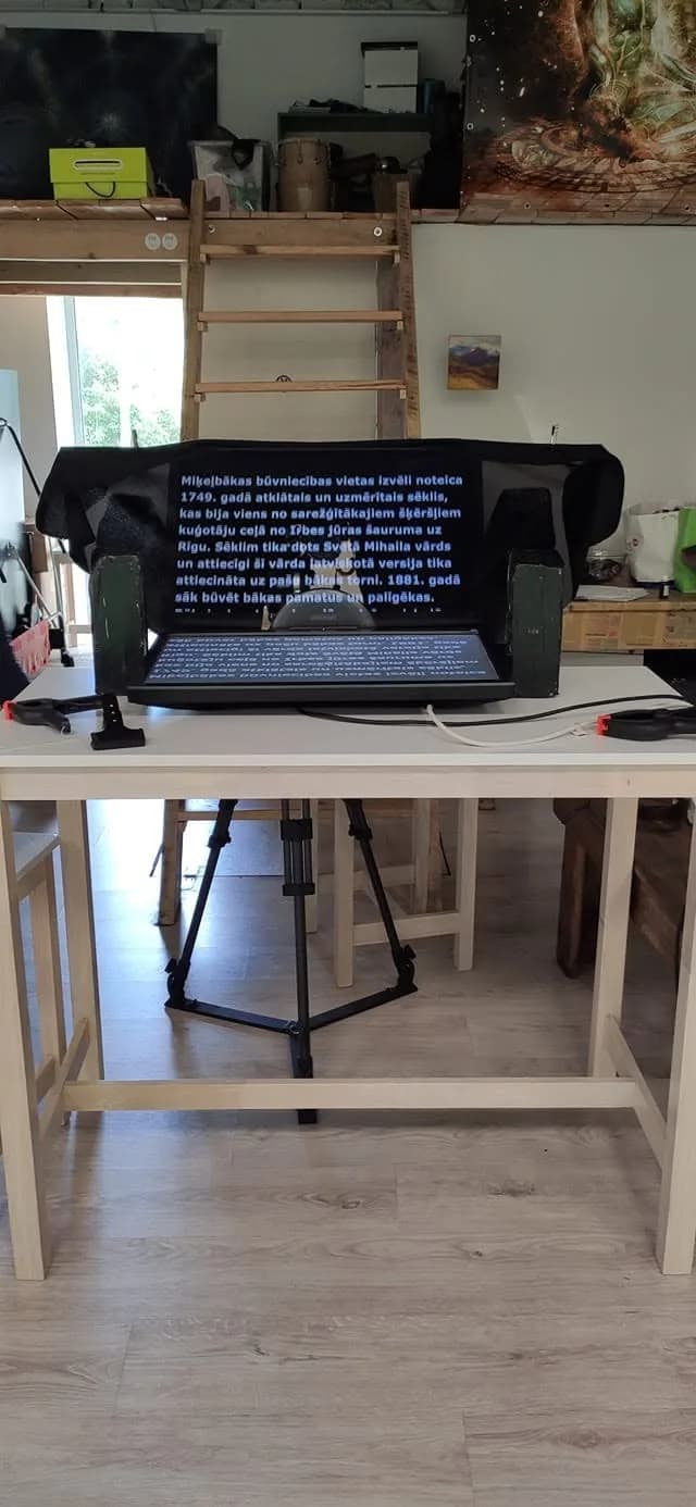 Teleprompter monitor displaying a script on a tripod rig