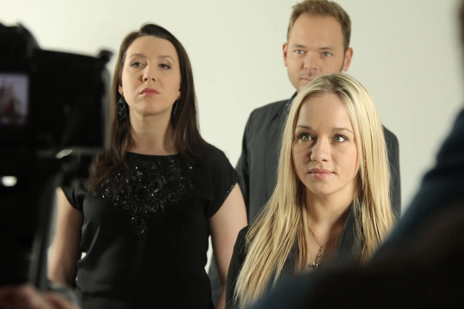 Three crew members on set during a studio shoot