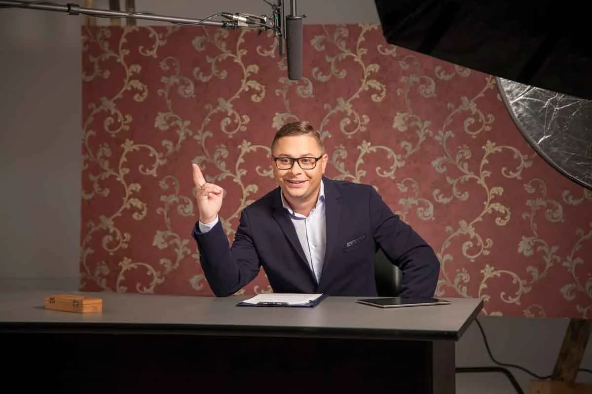 Close-up of a presenter mid-take at an on-camera interview desk