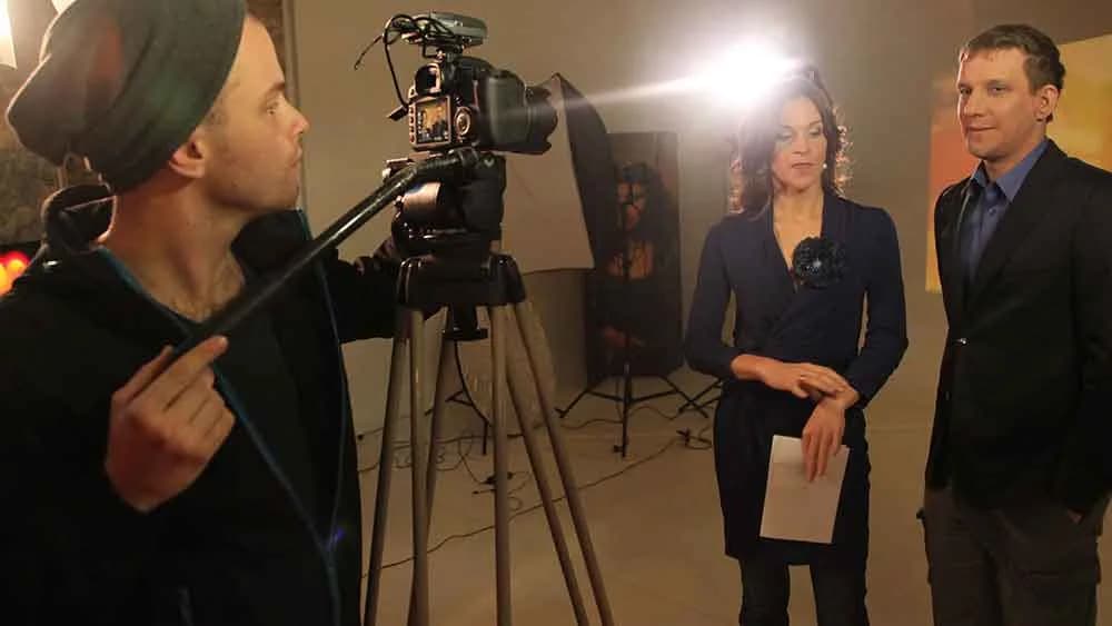 Boom operator and two presenters lit by a softbox during a shoot