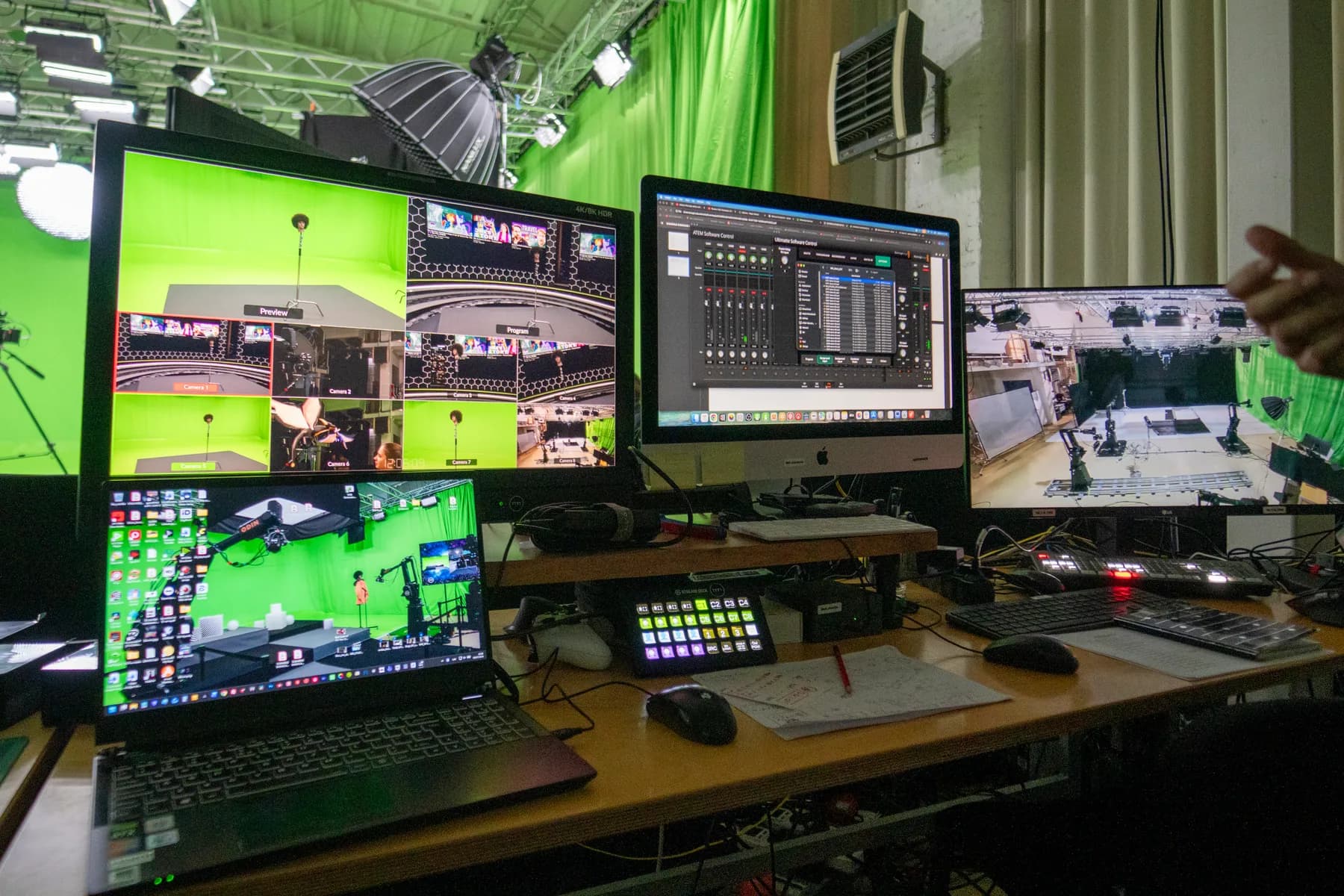 Wide view of a chromakey studio floor with robotic camera rigs and crew