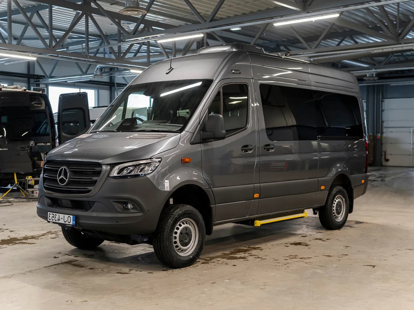 Oriģinālais foto pelēkam Mercedes Sprinter mikroautobusam, novietotam darbnīcas garāžā