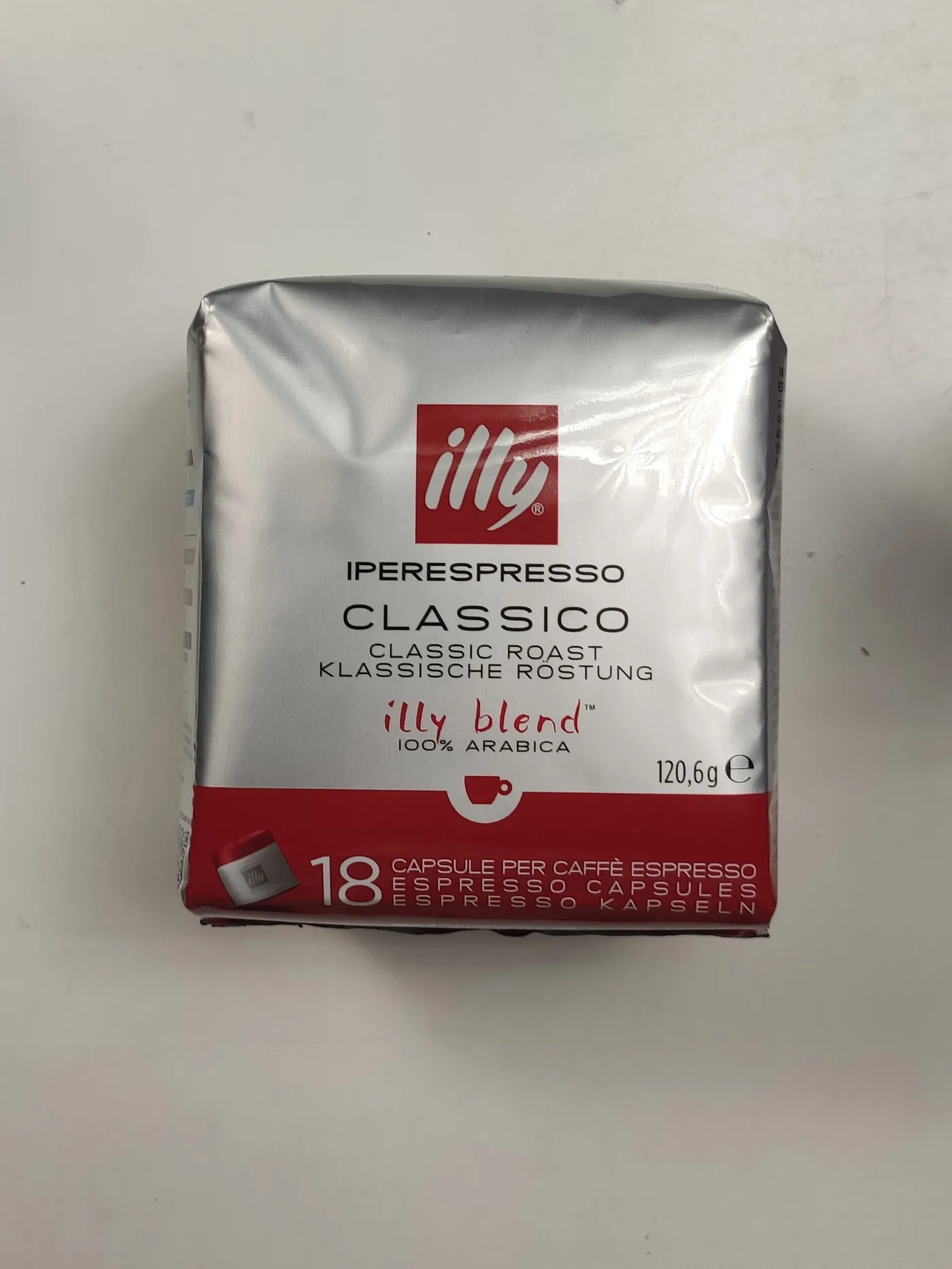 Oriģinālais studijas foto illy Iperespresso Classico kafijas kapsulu iepakojumam uz vienkrāsaina fona